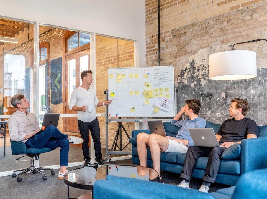A team leader discussing a sales velocity calculation with sales employees sitting on a couch