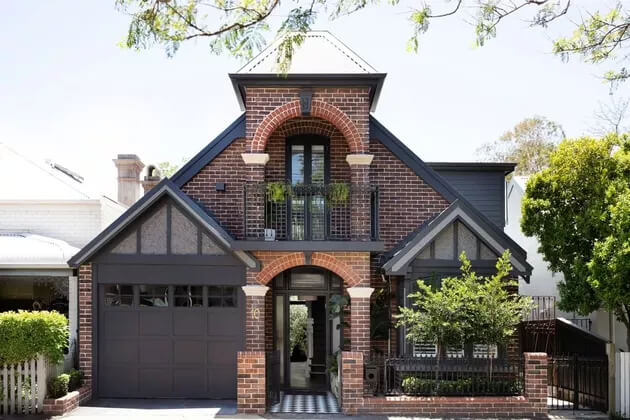 blue sliding and red brick house exterior (Three Birds Renovations)