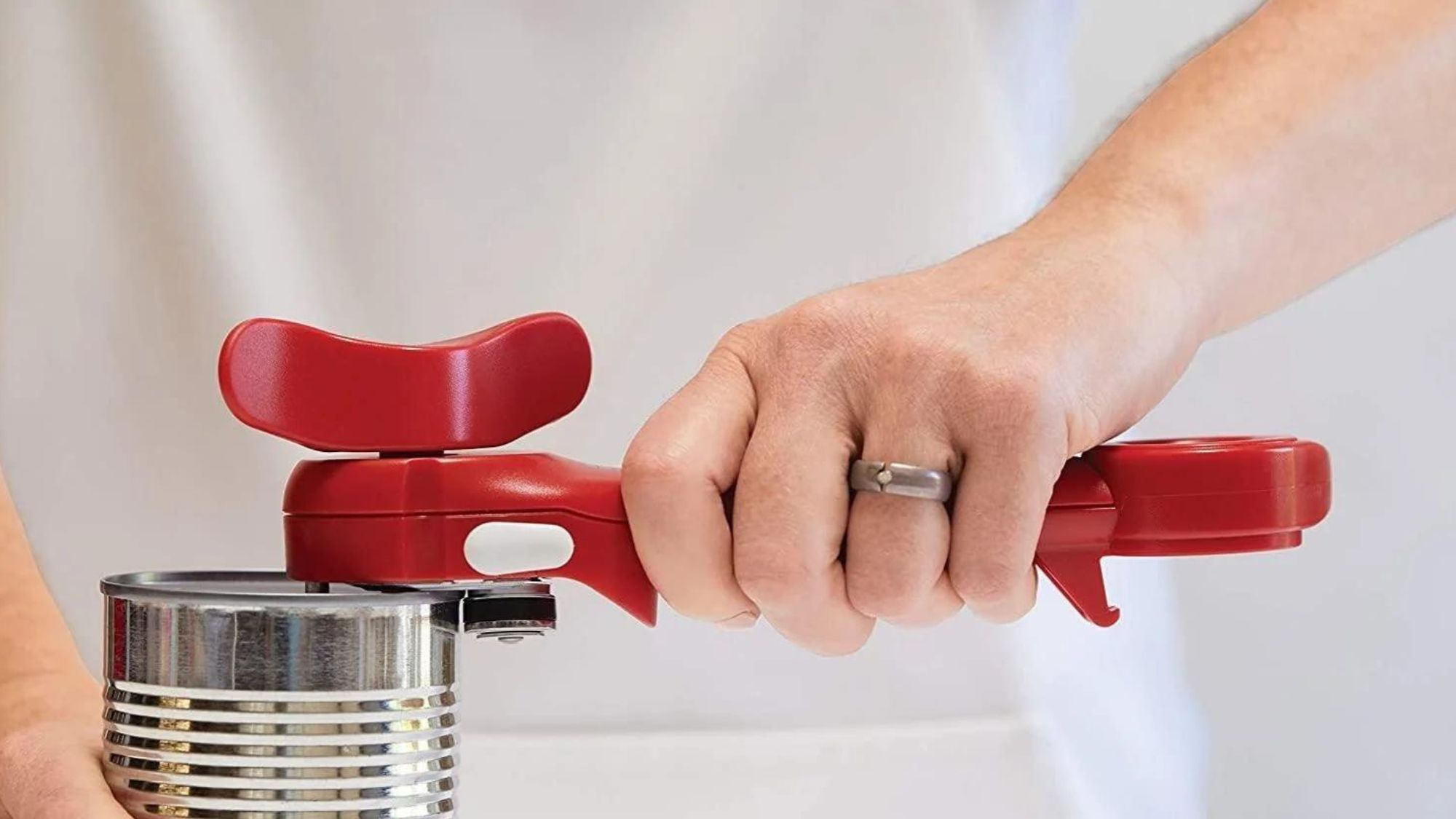 A woman opening a can with essential cooking equipment